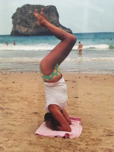 Figura de mujer haciendo yoga en la playa